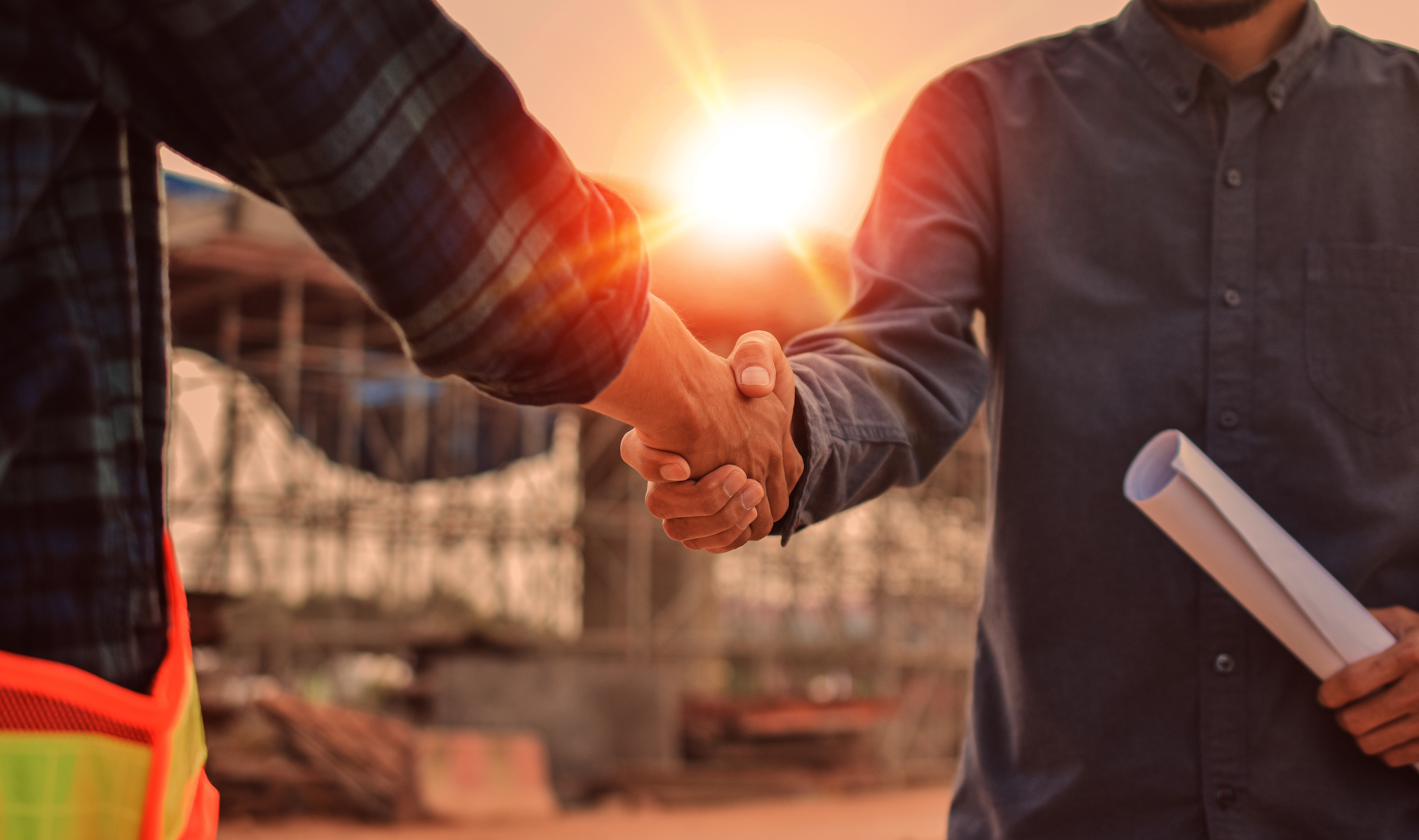 Construction site meeting with a handshake